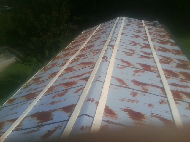 Rusted metal roof panels with new wood purlins before replacement — Storm Damage Roof Repair in Jacksonville by Roofing Brothers